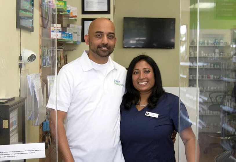 man in white and woman in dark blue smiling in front of the camera